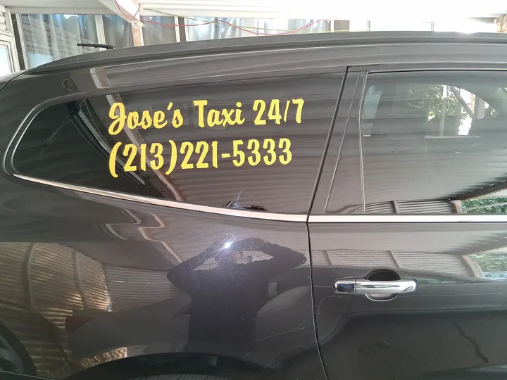 Jose's Taxi 24/7 name and phone number on the side of Jose's vehicle